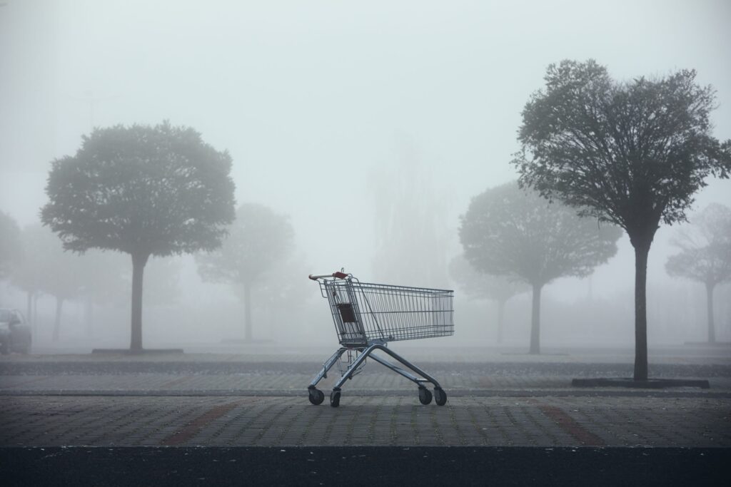 abandoned shopping cart on parking lot in thick