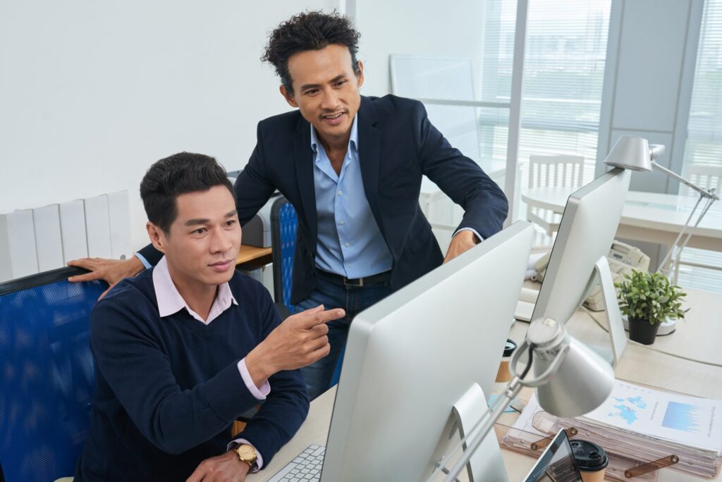 businessmen looking at data on computer
